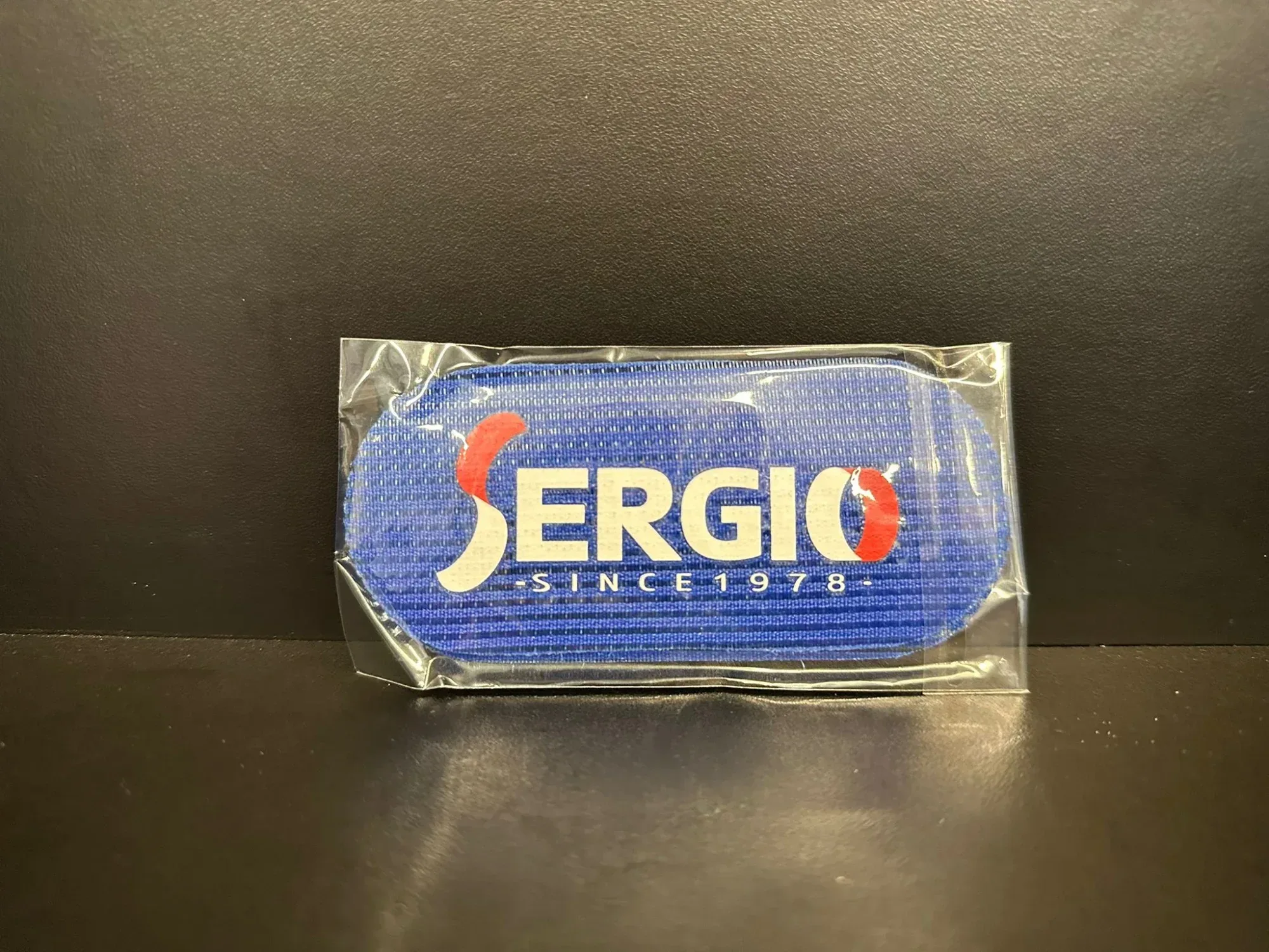 מוצר מקצועי לשיער בצבע כחול עם הלוגו של "SERGIO" על גבי אריזת פלסטיק.