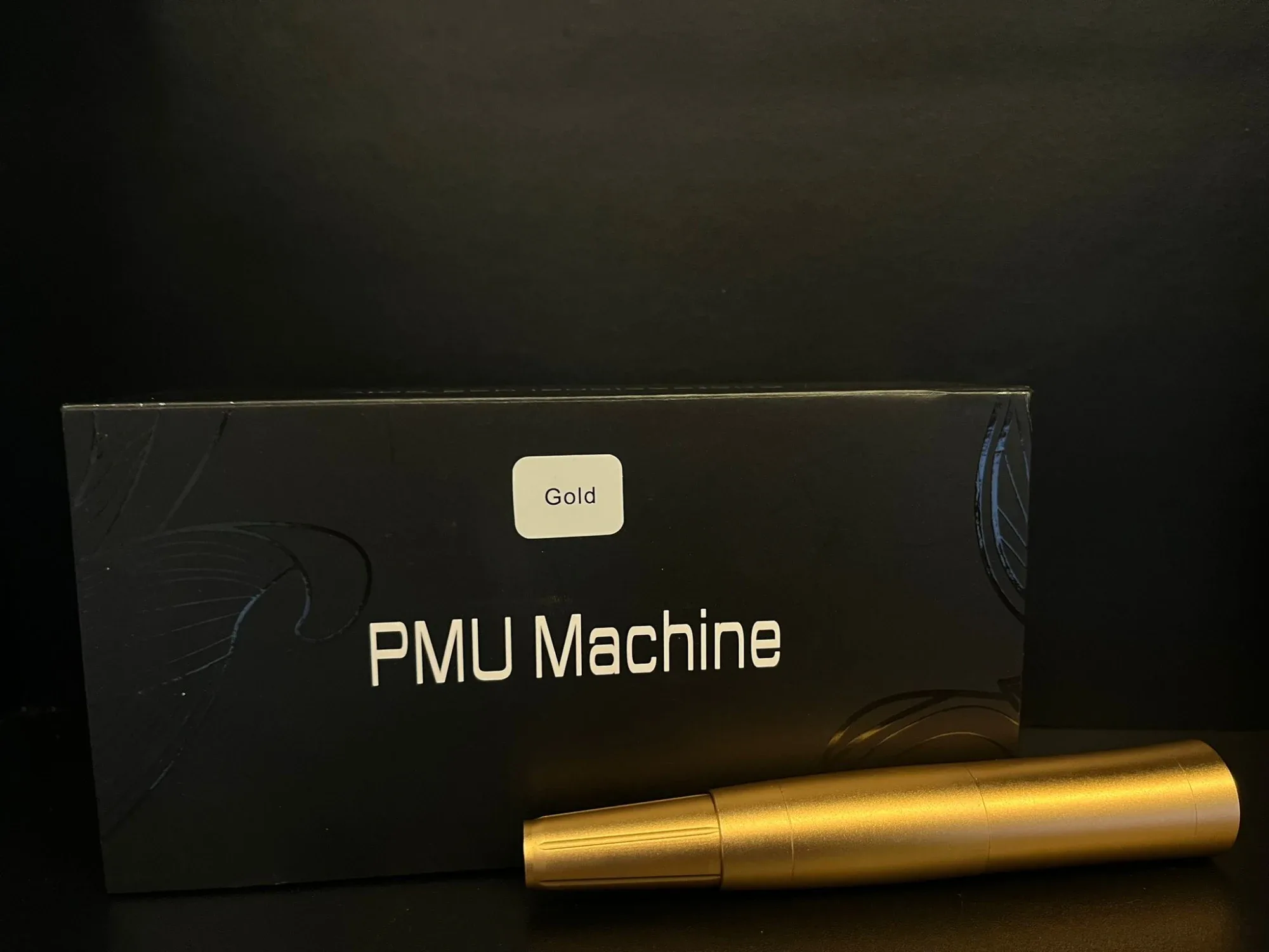 מכונת PMU בצבע זהב באריזת קרטון, מתאימה לקורסים באיפור קבוע ולימודי קוסמטיקה.